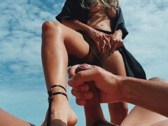 Blonde babe pleasures a guy's cock with her feet, masturbates, and makes him cum at a public nudist beach
