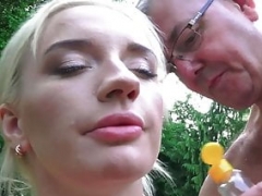 Russian kitten gets a massage from grandpa in the park