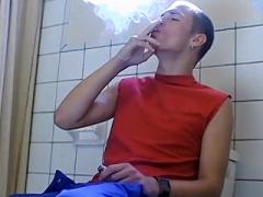 Twink tugs on his cock while smoking in the bathroom
