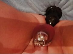Sissy in chastity trying to insert big plug
