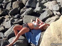 Busty blonde MILF flaunts her assets on a public beach