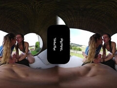 Blonde and brunette students take turns sucking on a huge cock in a hot VR threesome