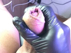 Precum dripping from pulled back foreskin in extreme close-up