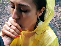 Slutty Brunette in a yellow raincoat sucks me outdoors in the rain