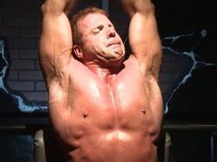 Moaning and trying not to show the pain in a BDSM setting