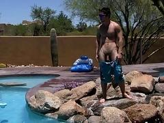Sporty jock relaxes by the pool and strokes his shaft