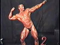 Bodybuilder's dick comes over top of posers on stage