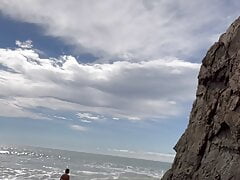 playing at nude beach with ocean waves naked