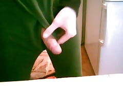 A young guy sticks his big sweet cock out of his pants and jerks it off and strokes it while standing in his kitchen