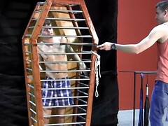 Caged boy is being whipped and seduced through BDSM