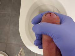 Jerking doctor at a toilet with latex gloves
