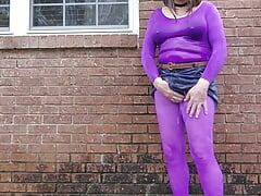 Crossdressed outdoors in nylon bodysuit getting wet in the rain.