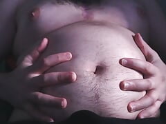 Chubby guy plays with his belly, masturbates and cums on his belly