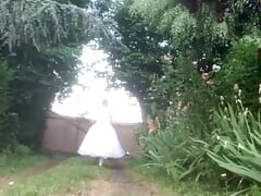 Second white wedding dress in satin and tulle on a walk