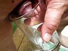 Small Asian dick pees into glass
