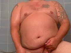 Witness the plump daddy shower, stroke, and ejaculate on his feet