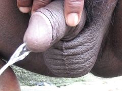 Indian Black Guy using Piss to refresh himself outdoors