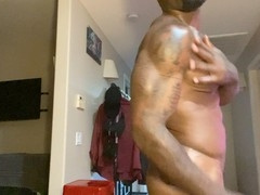 Muscular black god Kris Adonis shows off his pecs and meaty black cock while getting worshipped